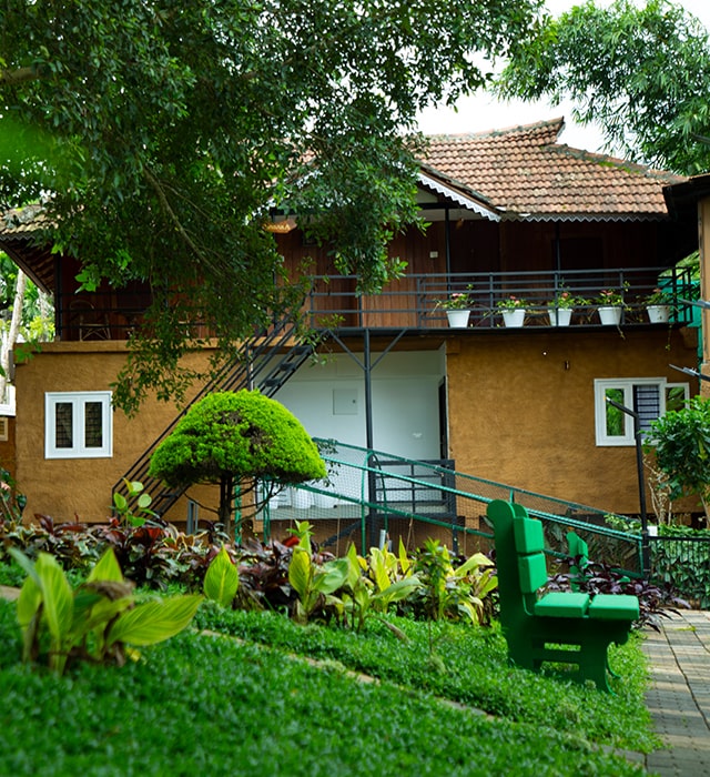 A cozy wooden cottage with a balcony, in Kabini Mystery Maze Resort and surrounded by nature